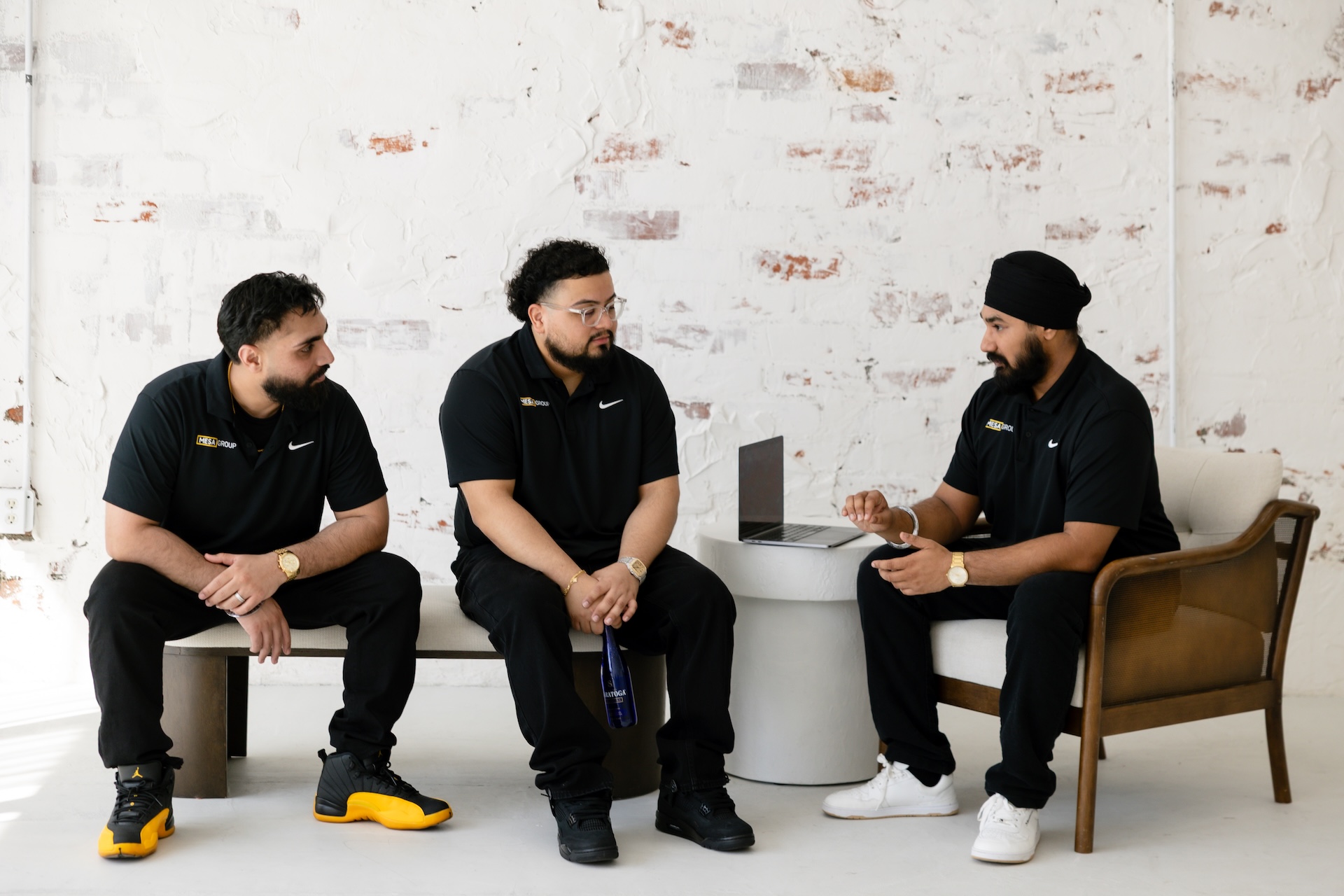 Equipo de Mesa Group Consulting en una animada discusión de estrategia, Gurtej Singh gesticulando con Evert Calderon y Harpreet Moore