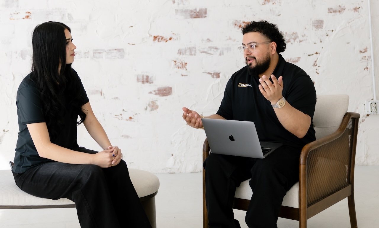 Evert Calderon de Mesa Group Consulting de pie con una MacBook abierta